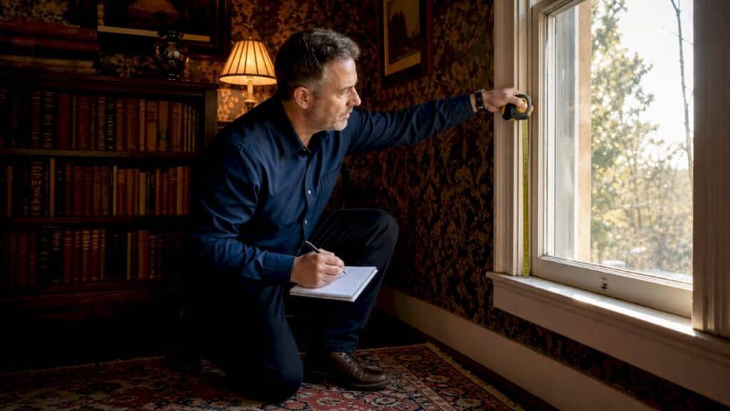 Specialist inspecting old home window frame
