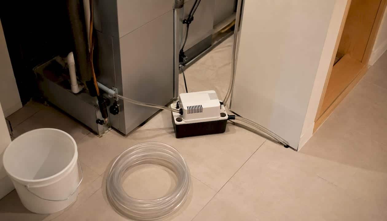 Condensate pump installed beside air handler in basement