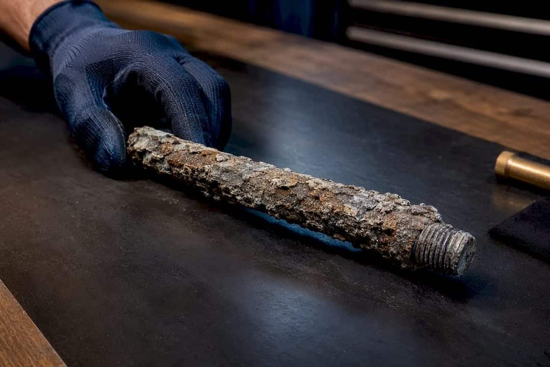 Heavily corroded anode rod on workbench