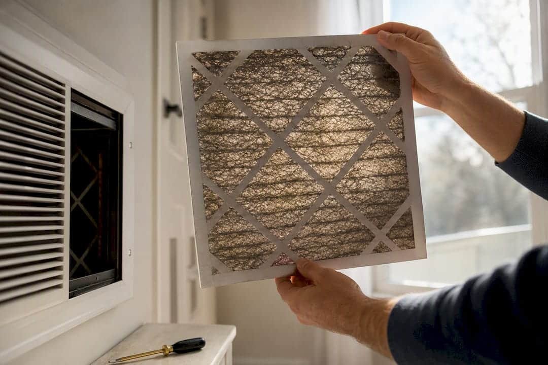 Homeowner checking a clogged AC filter